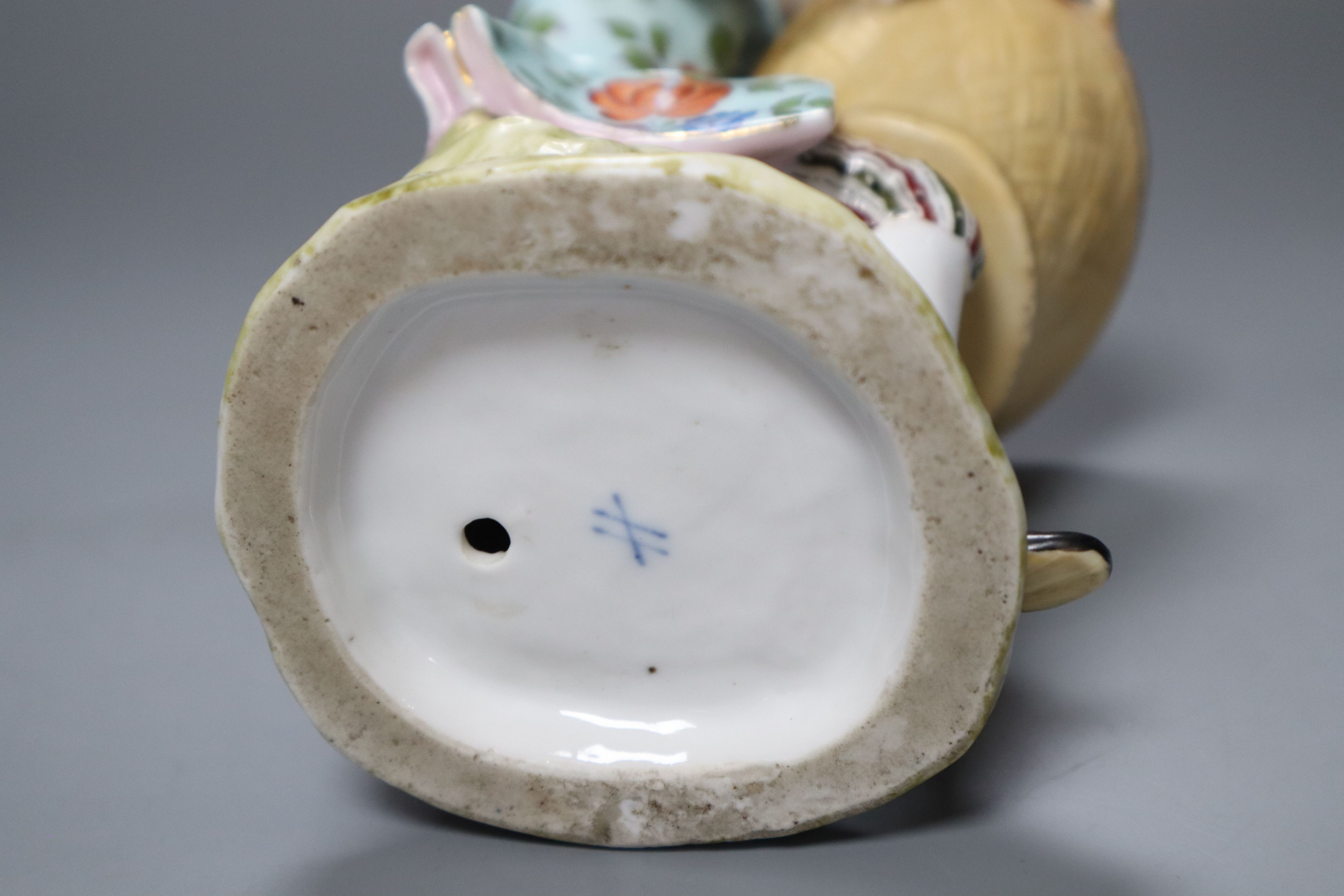 A Sitzendorf porcelain figure of a youth holding a basket, after a Meissen original by J.J. Kaendler, height 19cm